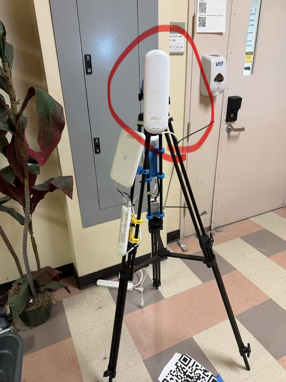 WiFi extender white antenna mounted on a black tripod, with the flat radiating face circled in red